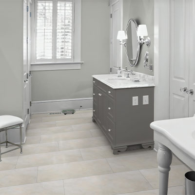 stone look luxury vinyl tile in bathroom with grey cabinet