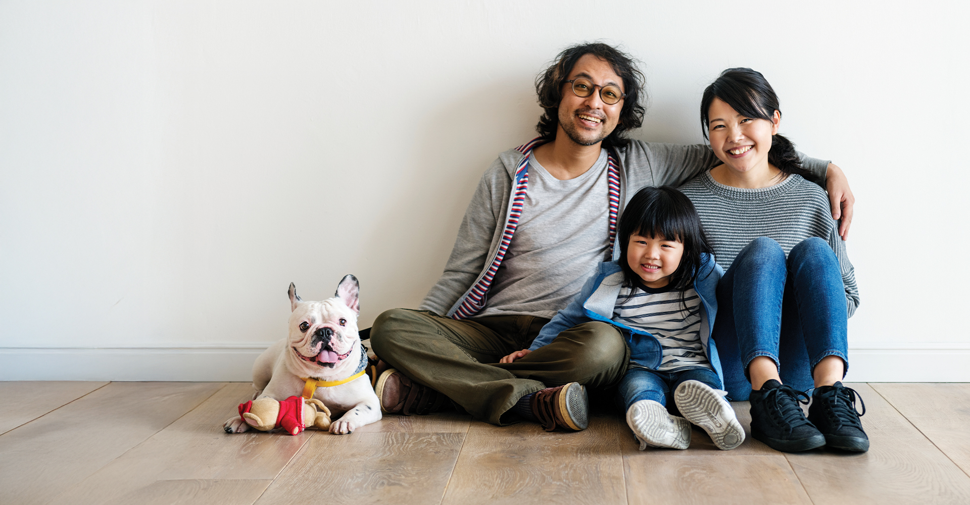 Woman sitting on a hardwood floor with a coffee mug in her hand.