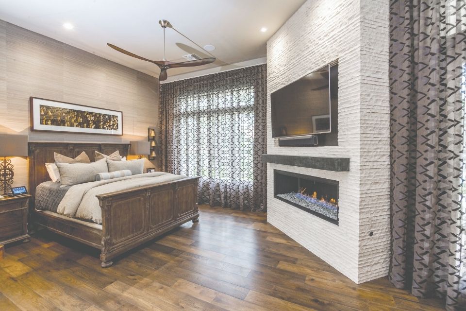 Dark brown Emser tile flooring in bedroom with large fireplace 