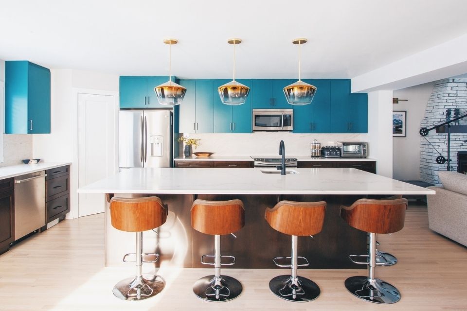 Teal blue cabinets in mid-century modern kitchen with leather seating