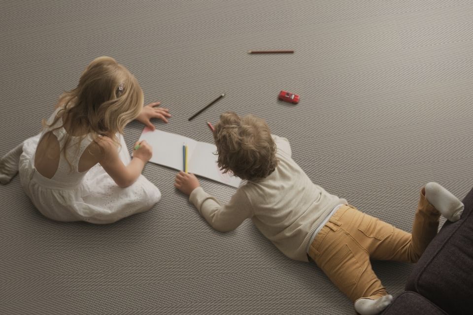 Kids coloring on kid-friendly, gray flooring