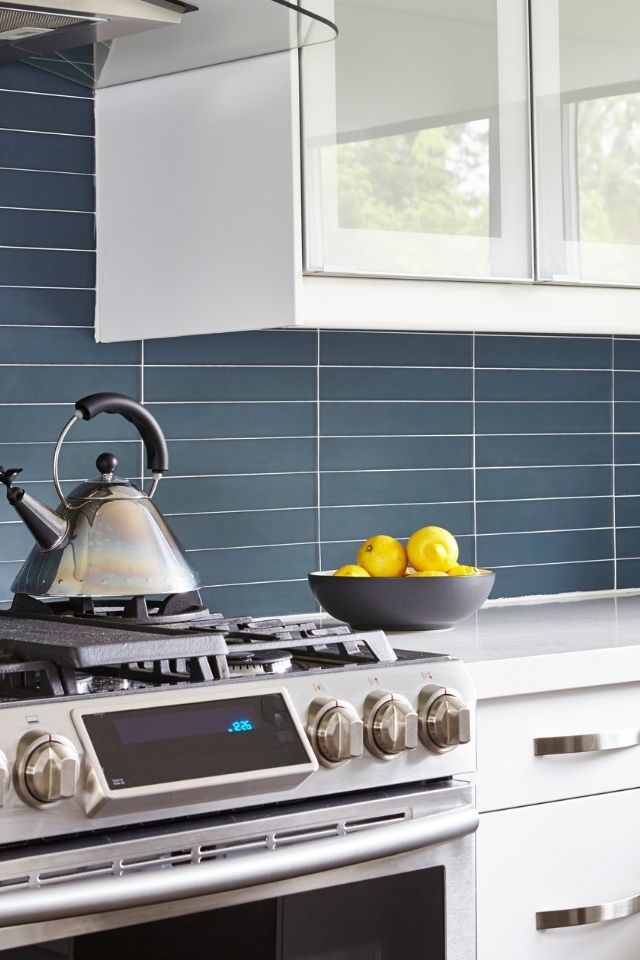 Blue tile backsplash in kitchen with white grout 