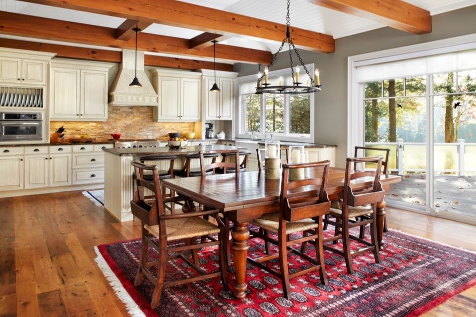 Warm red area rug under dining room table in open-concept kitchen and dining space with fall colors 