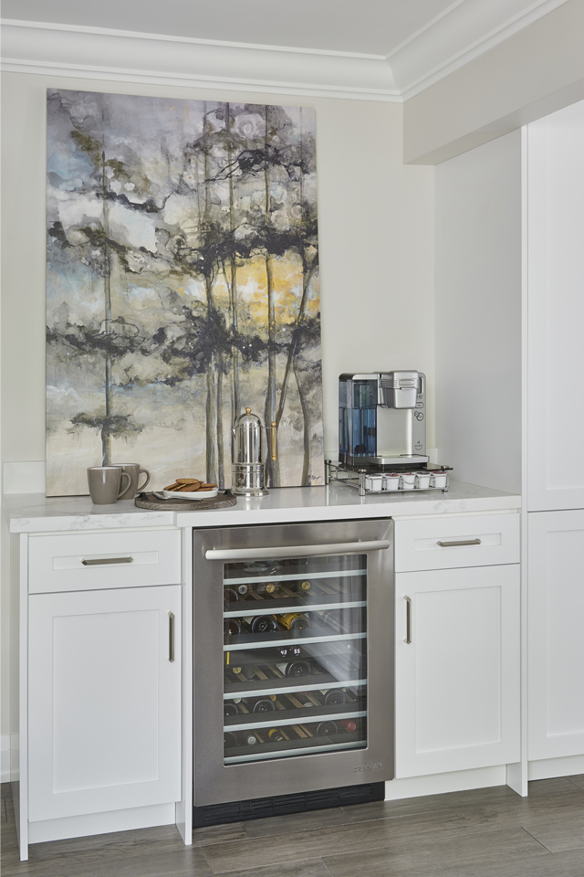 Built in nook in dining room with wine cooler and white cabinetry 