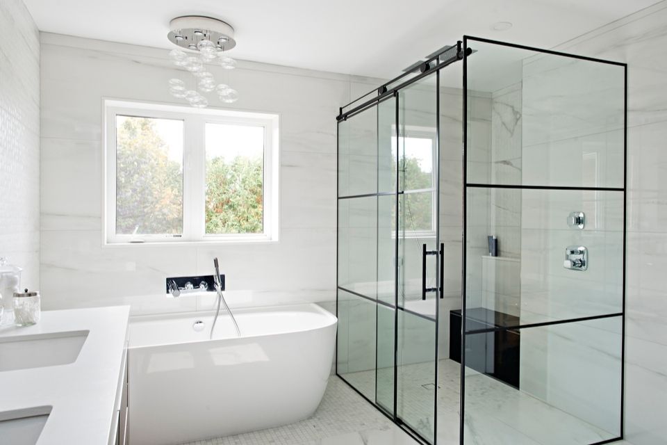 Black and white bathroom with enclosed shower surround and soaking tub 