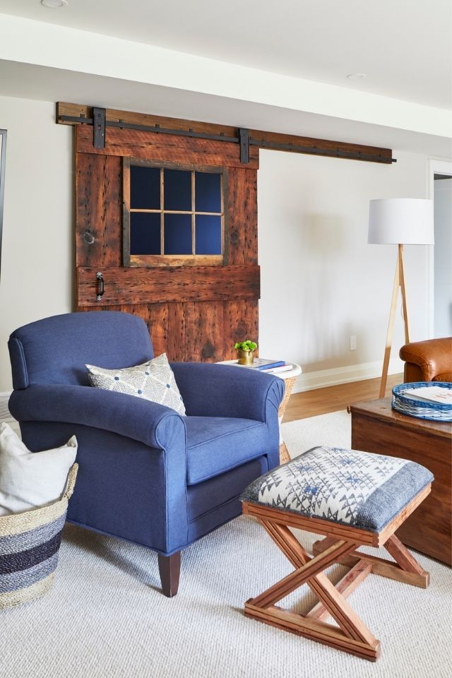 Living room chair with ottoman and sliding wood barn door in cozy living room 