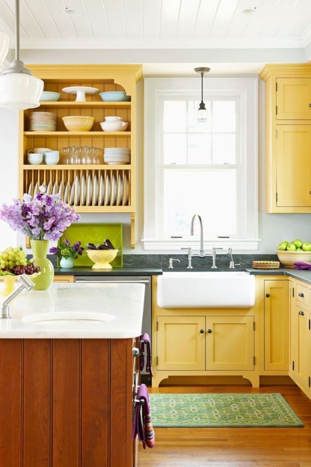 Pale yellow kitchen cabinets in old farmhouse kitchen with open shelving 