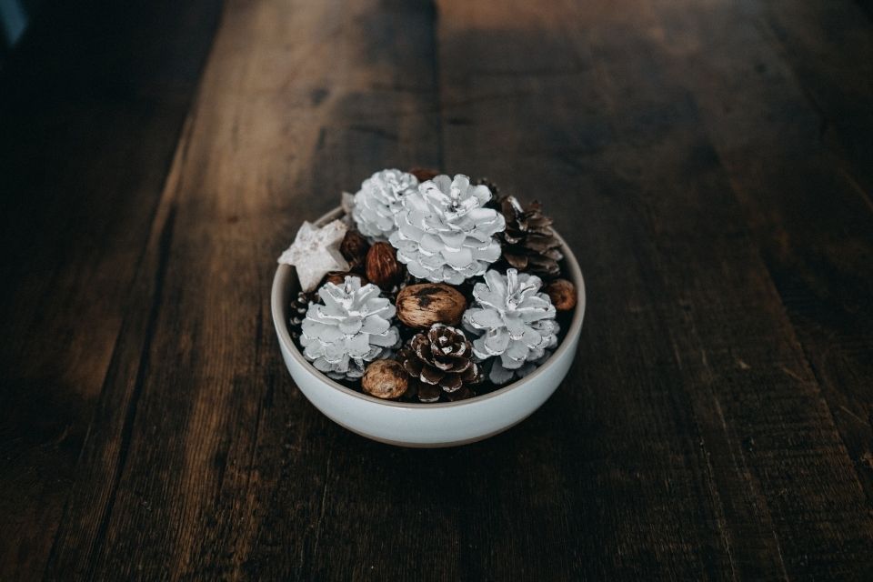 Pinecones in a bowl on top of a wood background 