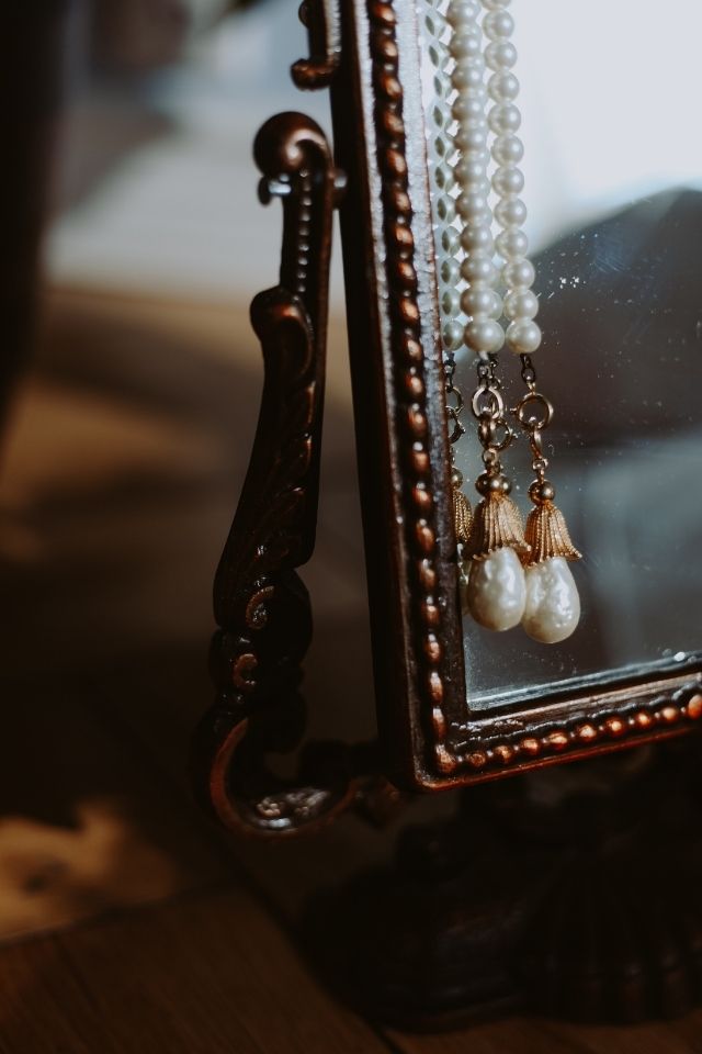 Antique jewelry hanging on mirror