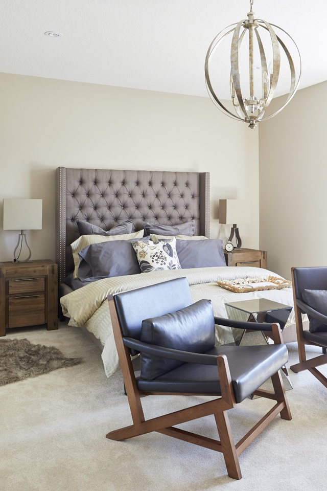 Cozy multifunctional bedroom with round light fixture and leather seating 