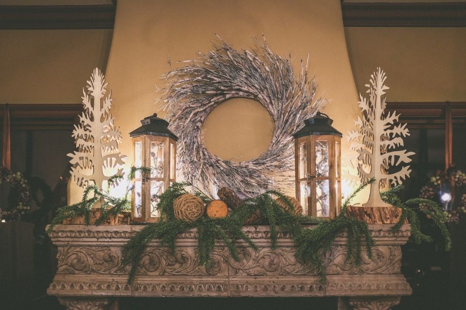 Thanksgiving decor on top of fireplace mantle with lanterns and garland 